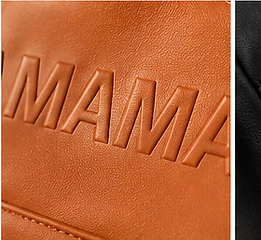 Close-up of the embossed MAMA lettering on the cognac Weekender